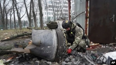 Một sĩ quan Ukraine kiểm tra bộ phận tên lửa gần một tòa nhà dân cư bị hư hại do cuộc tấn công bằng tên lửa của Nga ở Kharkiv, Ukraine, ngày 2/1/2024.