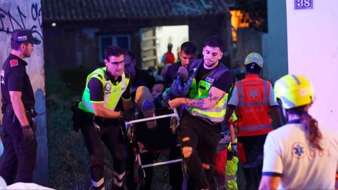 Nhân viên y tế đưa những người bị thương ra khỏi tòa nhà bị sập ở Palma de Mallorca. (Ảnh: AP)