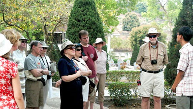 Du khách nghe giới thiệu về chiến thắng Điện Biên Phủ khi tham quan Nghĩa trang liệt sĩ Điện Biên. 