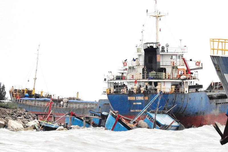 Tàu cá ngư dân và tàu hàng tại cảng Hòn La (Quảng Bình) bị sóng đánh dạt vào bờ Ảnh: MINH PHONG
