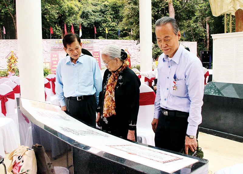 Nguyên Chủ tịch nước Nguyễn Minh Triết (bìa trái) và các đại biểu xem lịch sử hình thành di tích Căn cứ Dân Chính đảng Trung ương Cục miền Nam
