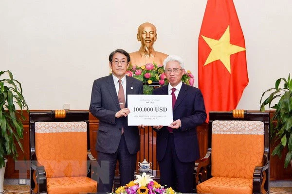 Đại diện Bộ Ngoại giao đã trao cho Đại sứ Nhật Bản tại Việt Nam khoản hỗ trợ. (Ảnh: TTXVN )