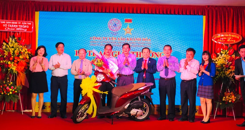 Ban lãnh đạo Công ty Yến Sào Khánh Hoà trao thưởng cho khách hàng trúng thưởng xe máy Honda SH Mode. Ảnh: HỒNG MINH