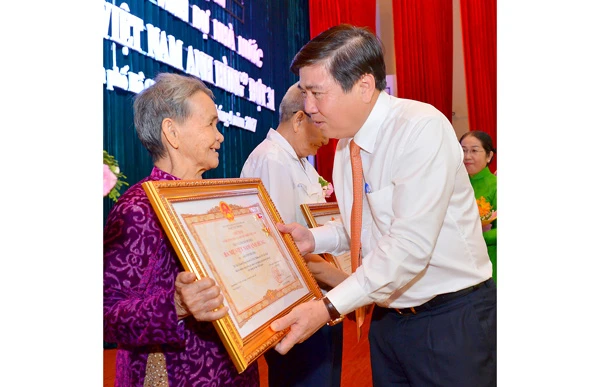 Chủ tịch UBND TPHCM Nguyễn Thành Phong trao danh hiệu “Bà Mẹ Việt Nam anh hùng” cho các gia đình. Ảnh: VIỆT DŨNG