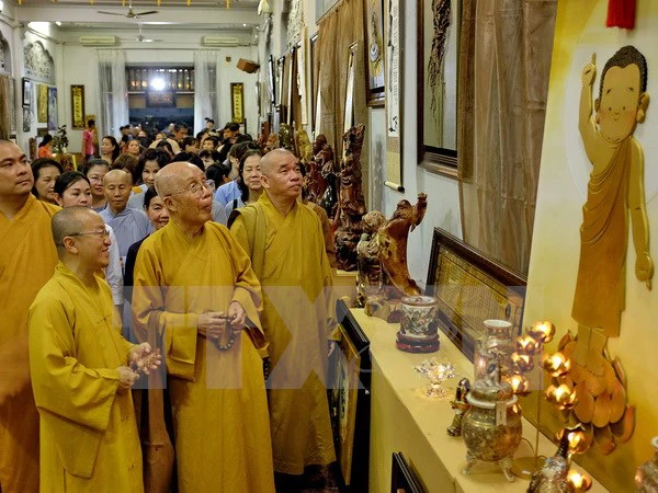 Các Chư tôn giáo phẩm cùng đông đảo phật tử tham quan triển lãm văn hóa nghệ thuật Phật giáo với hơn 500 tác phẩm từ tranh ảnh, tượng và sản phẩm điêu khắc tại tuần lễ văn hóa. Ảnh: TTXVN