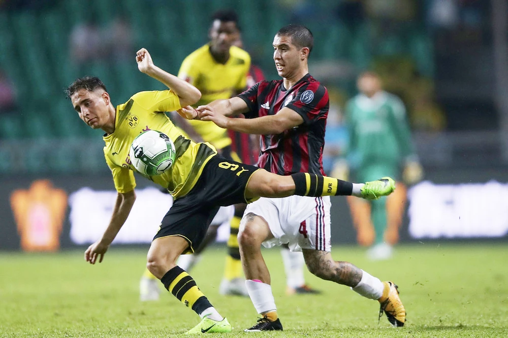 Jose Mauri (phải, AC Milan) tranh bóng với tiền đạo Borussia Dortmund trên sân Quảng Châu, Trung Quốc.