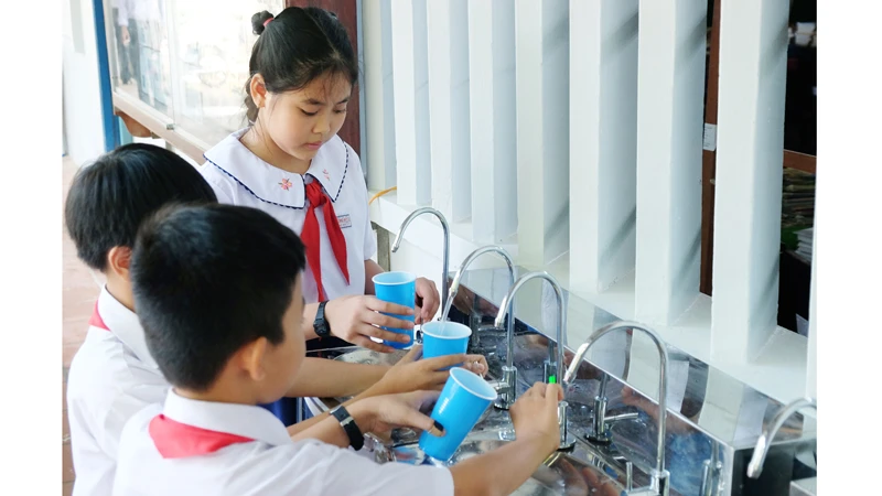  Các em học sinh Trường Tiểu học Hưng Mỹ 2, huyện Mỏ Cày, tỉnh Bến Tre uống nguồn nước sạch.