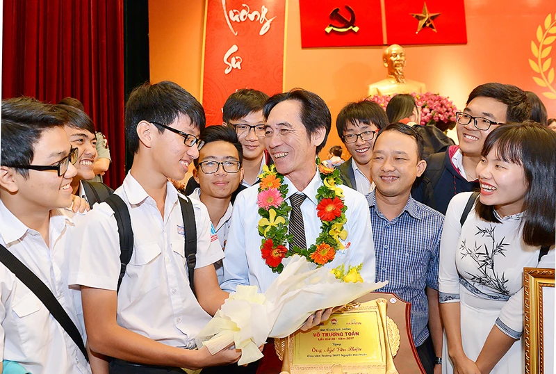 Thầy giáo Ngô Văn Thiệu (Trường THPT Nguyễn Hữu Huân) bên các học sinh trong ngày nhận Giải thưởng Võ Trường Toản. Ảnh: VIỆT DŨNG