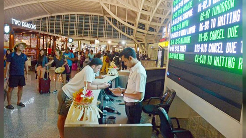Du khách xem thông tin chuyến bay tại sân bay Ngurah Rai, Bali, Indonesia ngày 25-11-2017. Ảnh: REUTERS