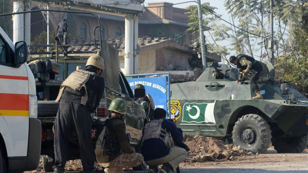 Quân đội Pakistan bao vây Học viện Nông nghiệp Peshawar, nơi các tay súng phiến quân tấn công. Ảnh: CNN