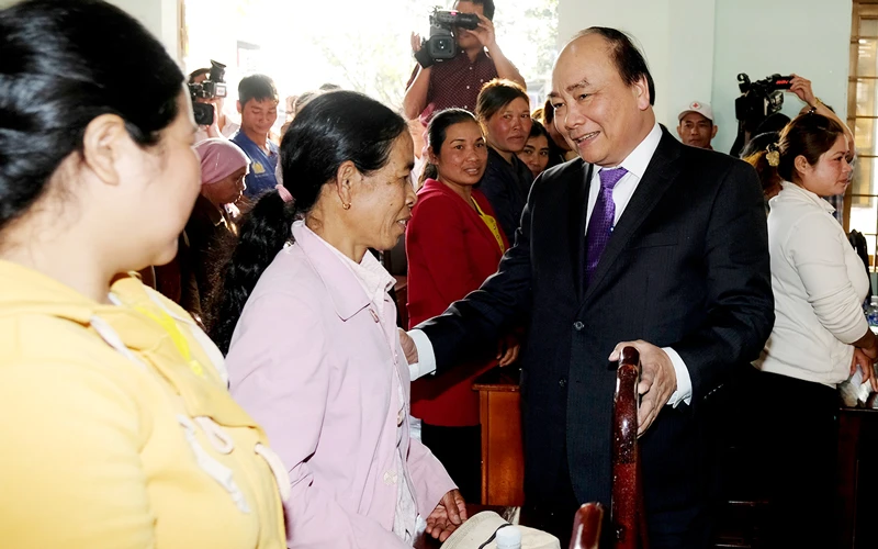 Thủ tướng Nguyễn Xuân Phúc cùng đồng bào xã Ea Tiêu, huyện Cư Kuin. - Ảnh: VGP/Quang Hiếu
