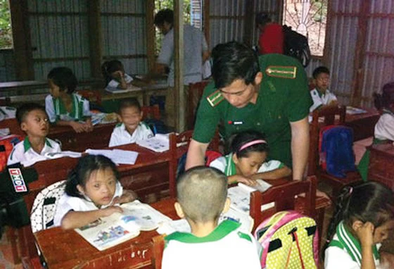 Thượng úy Trần Bình Phục đang hướng dẫn từng con chữ cho các cháu lớp học tình thương trên đảo Hòn Chuối(thị trấn Sông Đốc, huyện Trần Văn Thời, tỉnh Cà Mau).