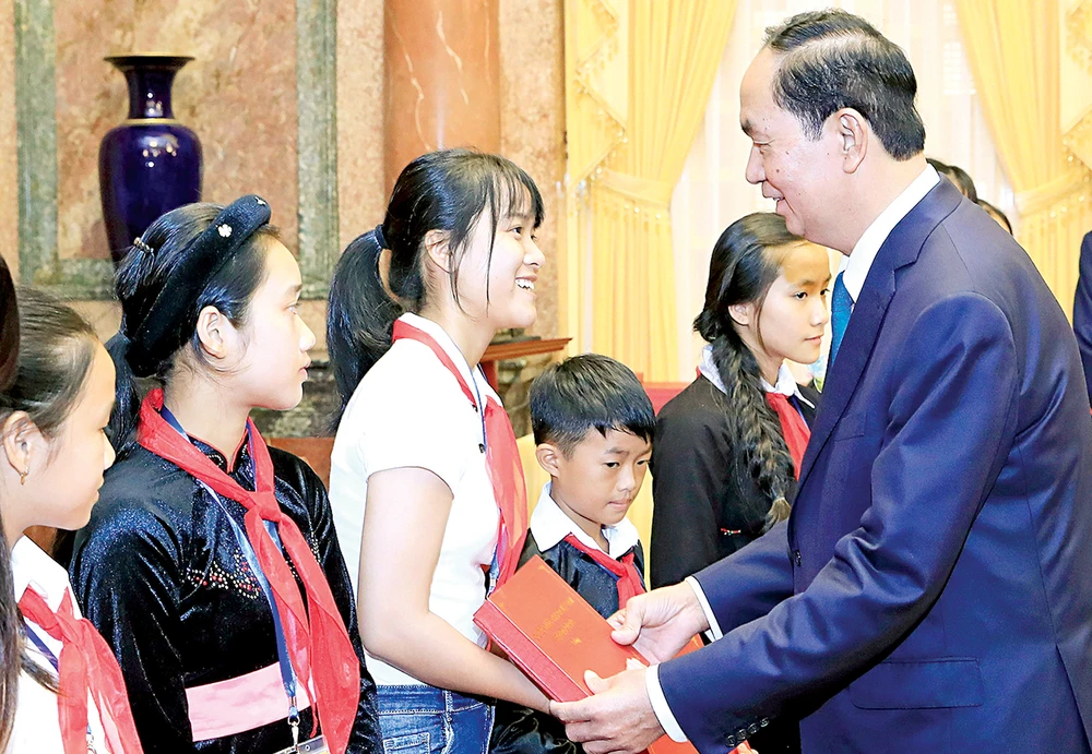Chủ tịch nước Trần Đại Quang tặng quà các trẻ em có hoàn cảnh đặc biệt. Ảnh: TTXVN