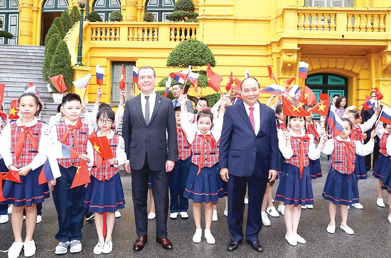 Thủ tướng Nguyễn Xuân Phúc và Thủ tướng Liên bang Nga Dmitry Medvedev chụp ảnh chung với thiếu nhi Hà Nội tại lễ đón. Ảnh: TTXVN