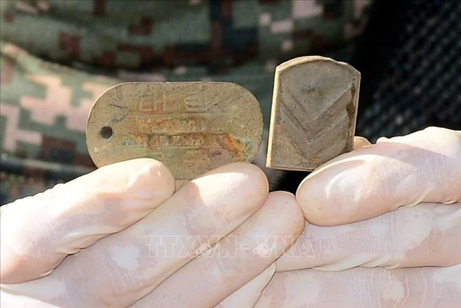 Tấm thẻ quân nhân và phù hiệu được tìm thấy cùng bộ hài cốt được cho là của một binh sĩ Hàn Quốc tử trận trong Chiến tranh Triều Tiên 1950-1953 tại Khu phi quân sự (DMZ) ở biên giới hai miền Triều Tiên, ngày 24-10-2018. Ảnh: Yonhap/TTXVN