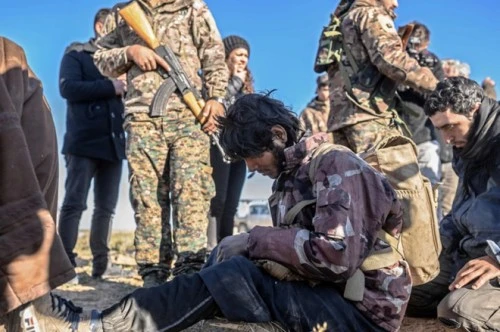 Những tay súng nghi thuộc IS bị SDF bắt giữ. Ảnh: Guardian 