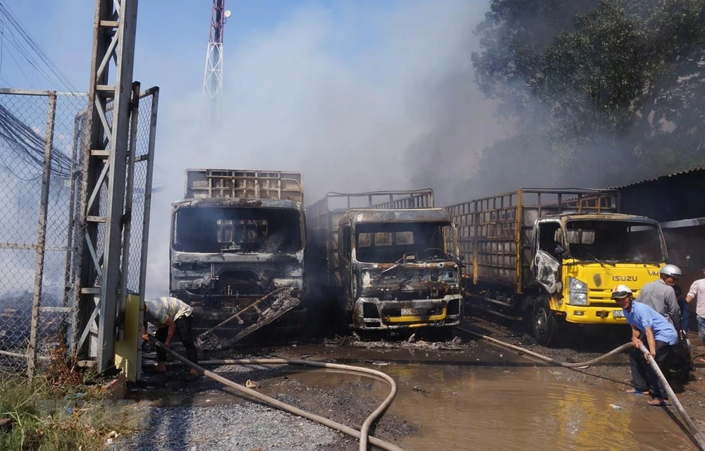 Vụ cháy làm 3 xe tải và nhiều tài sản khác bị thiêu rụi. Ảnh: TTXVN