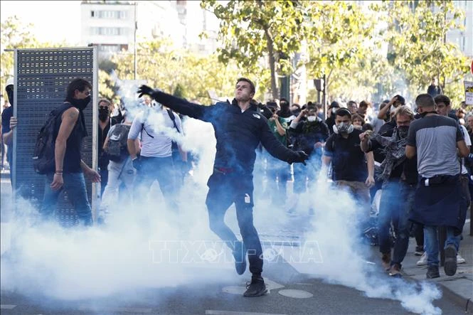 Người biểu tình bạo lực ném hơi cay trong cuộc tuần hành chống biến đổi khí hậu tại Paris, Pháp, ngày 21-9-2019. Ảnh: TTXVN
