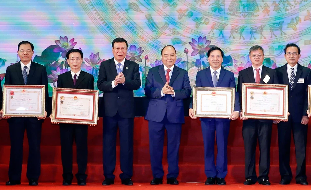 Thủ tướng Nguyễn Xuân Phúc trao tặng Huân chương Độc lập hạng Ba và Huân chương Lao động hạng Nhất cho các tập thể. Ảnh: TTXVN