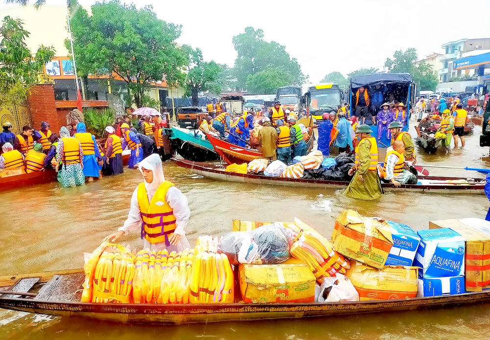 Người dân đổ về rốn lũ huyện Lệ Thủy, tỉnh Quảng Bình, để cứu trợ đồng bào bị ngập lụt. Ảnh: NGỌC OAI
