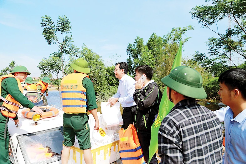 Anh Vũ Anh Tuấn (người mặc áo trắng) Phó TGĐ CPV cùng đoàn công tác của Bộ trưởng Bộ NN-PTNT trao tặng 100 suất quà tại vùng lũ huyện Lệ Thủy, tỉnh Quảng Bình