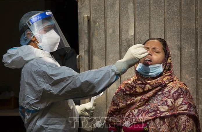 Nhân viên y tế lấy mẫu dịch xét nghiệm Covid-19 cho người dân tại New Delhi, Ấn Độ ngày 7-5. Ảnh: THX/TTXVN