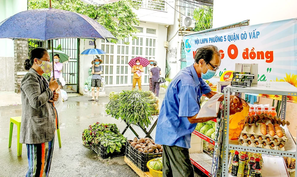 Người dân khu cách ly phường 5, quận Gò Vấp, TPHCM lần lượt vào kệ hàng 0 đồng lấy hàng hóa cần thiết trong ngày. Ảnh: HOÀNG HÙNG