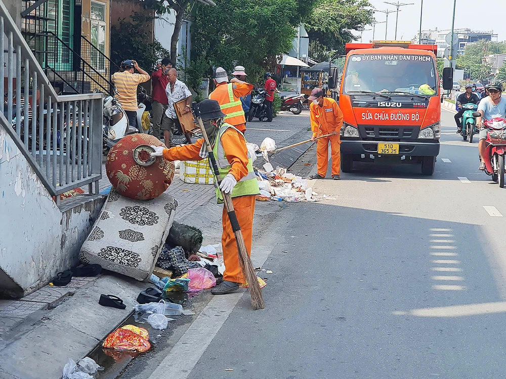 Đơn vị thu gom rác của thành phố thu dọn các bãi rác hoang trên đường Phạm Văn Đồng