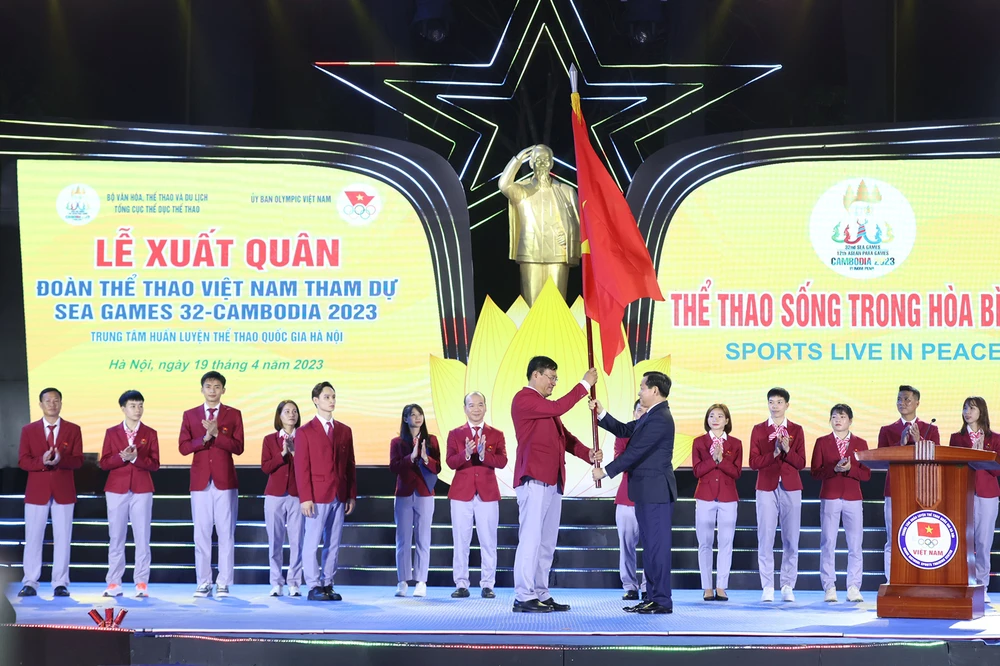 Phó Thủ tướng Lê Minh Khái trao cờ cho Trưởng Đoàn thể thao Việt Nam Đặng Hà Việt tại lễ xuất quân. Ảnh: PHƯƠNG MINH