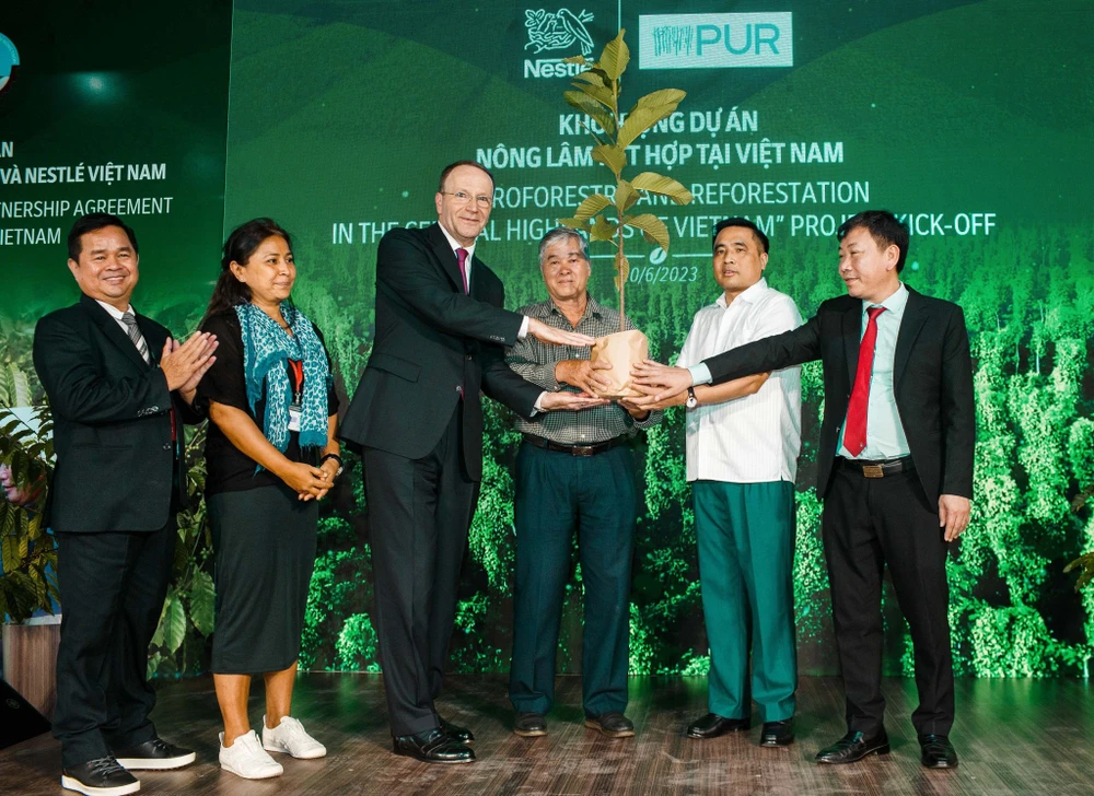 Ông Mark Schneider, Giám đốc điều hành Tập đoàn Nestlé (thứ 3 từ trái sang) trao cây đến người nông dân (thứ 4 từ trái sang), khởi động dự án nông lâm kết hợp tại Việt Nam