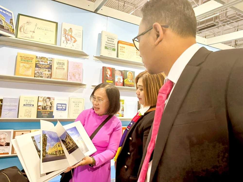 Bà Đinh Thị Thanh Thủy, Phó Chủ tịch Hội Xuất bản Việt Nam, Giám đốc - Tổng Biên tập Nhà xuất bản Tổng hợp TPHCM, giới thiệu với khách quốc tế các ấn phẩm trong gian hàng sách TPHCM