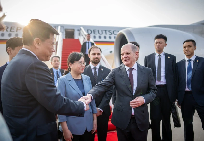 Thủ tướng Đức Olaf Scholz (phải) đang bắt tay với một quan chức Trung Quốc khi đến TP Trùng Khánh (Trung Quốc) hôm 14-4. Ảnh: BLOOMBERG