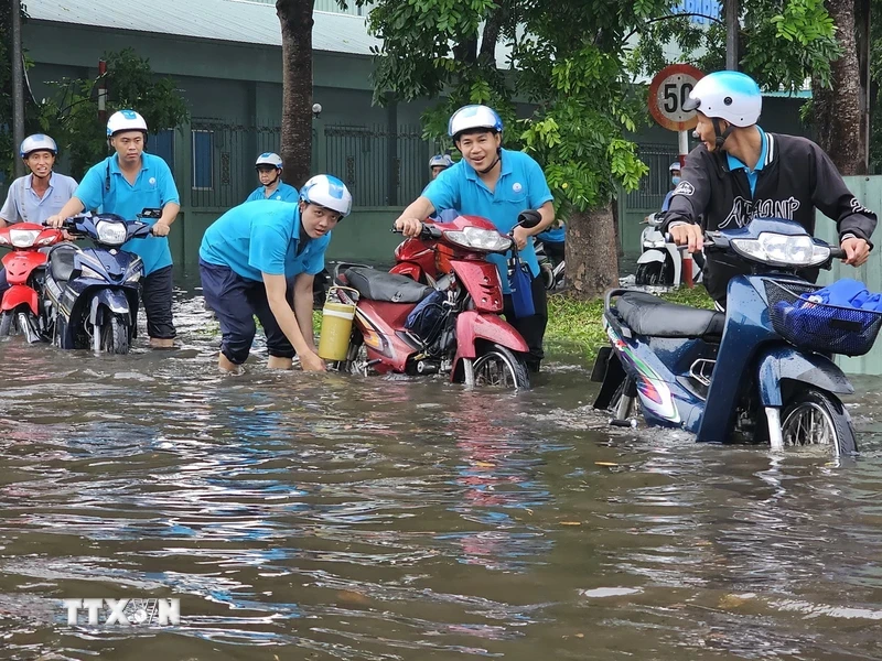 Nhiều công nhân lội nước đi làm tại Khu công nghiệp Giao Long. Ảnh: TTXVN