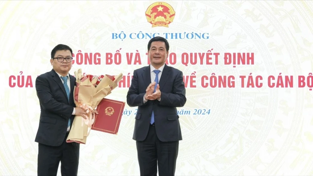 Bộ trưởng Bộ Công thương Nguyễn Hồng Diên (bìa phải) trao quyết định bổ nhiệm làm Thứ trưởng cho ông Trương Thanh Hoài ngày 28-6