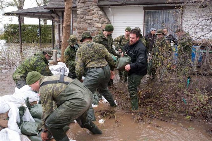 Soldiers help residents of Pierrefonds after heavy flooding caused by unrelenting rain. – AFP/VNA Photo