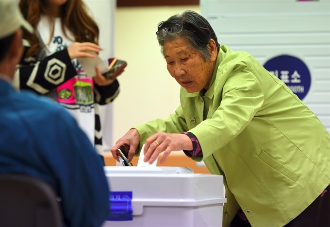 A South Korean elderly woman casts her vote in the presidential election at a polling station in Seoul on Tuesday. — AFP/VNA 