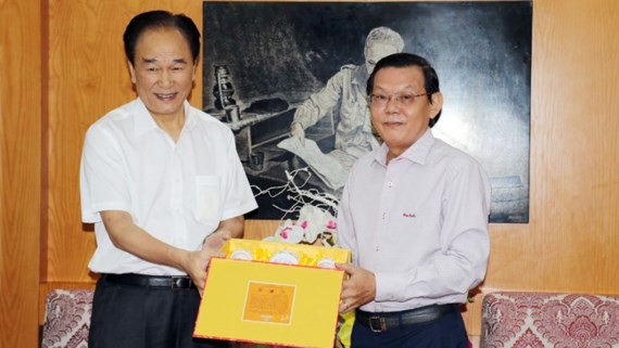 Xinhua President Cai Mingzhao hands over presents to Sai Gon Giai Phong Newspaper. (Photo: Sggp)