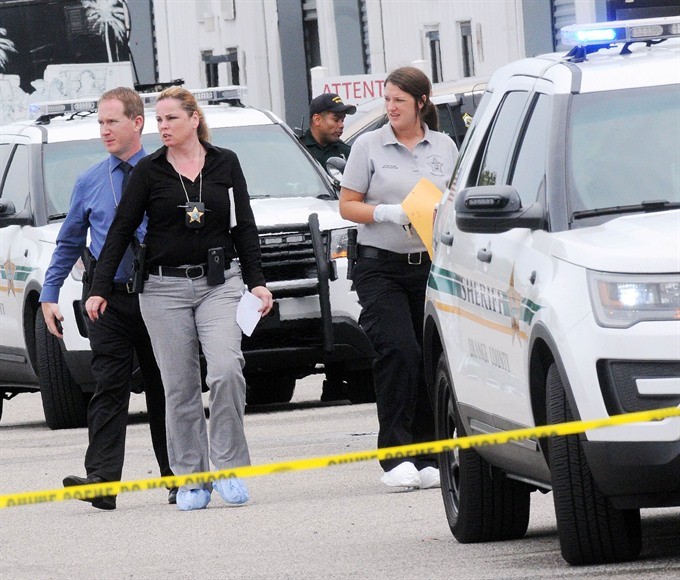 Investigators work the scene of a multiple shooting at an area business in an industrial area on Monday, northeast of downtown Orlando, Florida