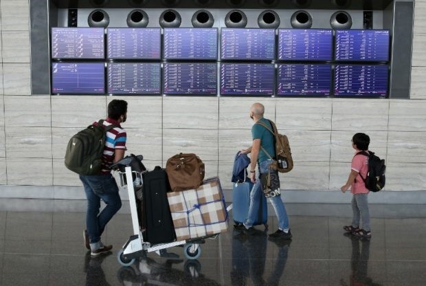 Passengers check the departures board at the Hamad International Airport in Doha on July 20, 2017. — AFP/VNA 