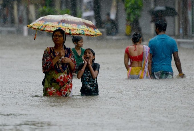 Days of intense monsoon downpours have deluged the densely-populated city of more than 20 million, paralysing crucial local train services and leaving commuters to wade through swirling waist-high waters. Photo AFP/VNS