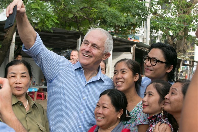 Australian Prime Minister Malcolm Turnbull takes a selfie with local residents in Danang