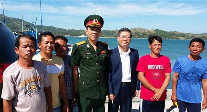 Vietnamese Ambassador to the Philippines Ly Quoc Tuan (third from right) and Defence Attache Nguyen Van Hung (centre) with five fishermen who return home after a ceremony on November 29 (Photo: VNA)