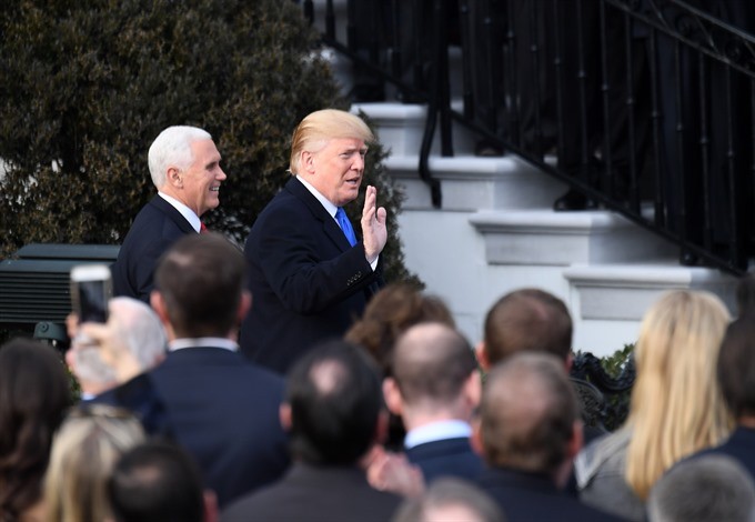 US President Donald Trump (R, rear) and Vice President Mike Pence (L, rear) arrive at an event celebrating the passage of the tax bill on the South Lawn of the White House in Washington DC, the US, on Wednesday.