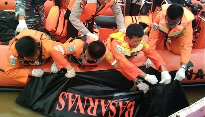 Members of a rescue team are retrieving a body from the Musi river in Palembang, South Sumatra province, after a boat carrying 55 people hit a large wave and sank amid bad weather. At least 13 people died. (Source: AFP)