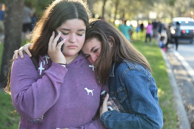 Students react following a shooting at Marjory Stoneman Douglas High School in Parkland, Florida, a city about 50 miles (80 kilometers) north of Miami on February 14, 2018. A gunman opened fire at the Florida high school, an incident that officials said c