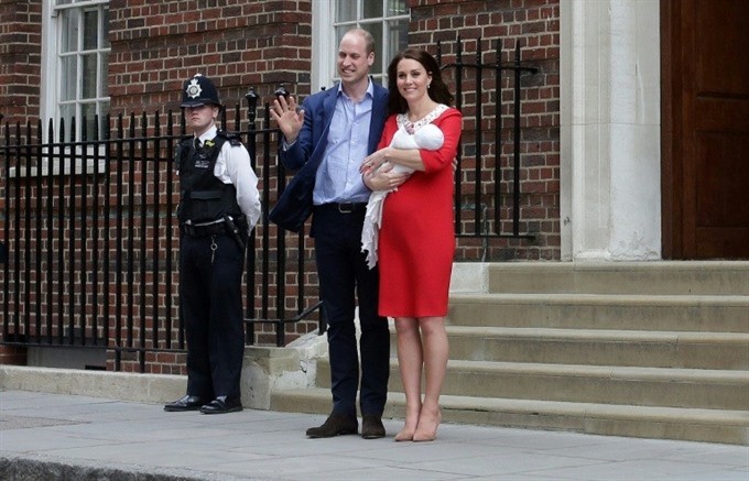 Britain’s Prince William and Kate, Duchess of Cambridge wave holding their newborn baby son. — AFP Photo