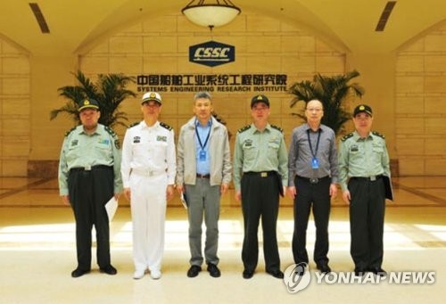 Mao Xinyu (L) poses for a group photo during his visit to China State Shipbuilding Corp. on May 4, 2018, in this picture posted on the company's website. (Yonhap)