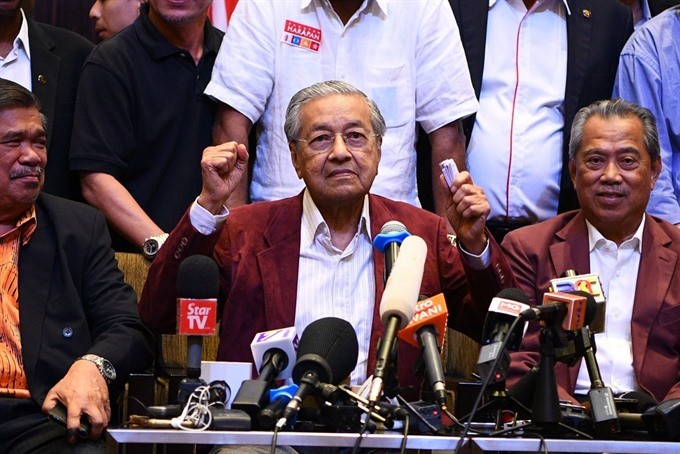 Former Malaysian Prime minister and opposition candidate Mahathir Mohamad celebrates with other leaders of his coalition during a press conference in Kuala Lumpur on early Thursday. — AFP/VNA Photo