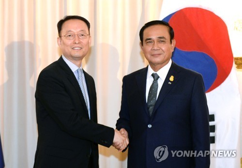 Paik Un-gyu, South Korean minister of trade, industry and energy (L), shakes hands with Thailand's Prime Minister Prayuth Chan-ocha (R) after their meeting in Bangkok on May 16, 2018, in this photo provided by the ministry. (Yonhap)
