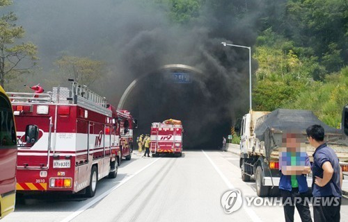 Firetrucks are in front of the Beomseo Tunnel on the expressway linking the southeastern cities of Ulsan and Pohang after a fire broke out in the unnel on June 22. Photo courtesy of the Ulsan fire department. (Yonhap)